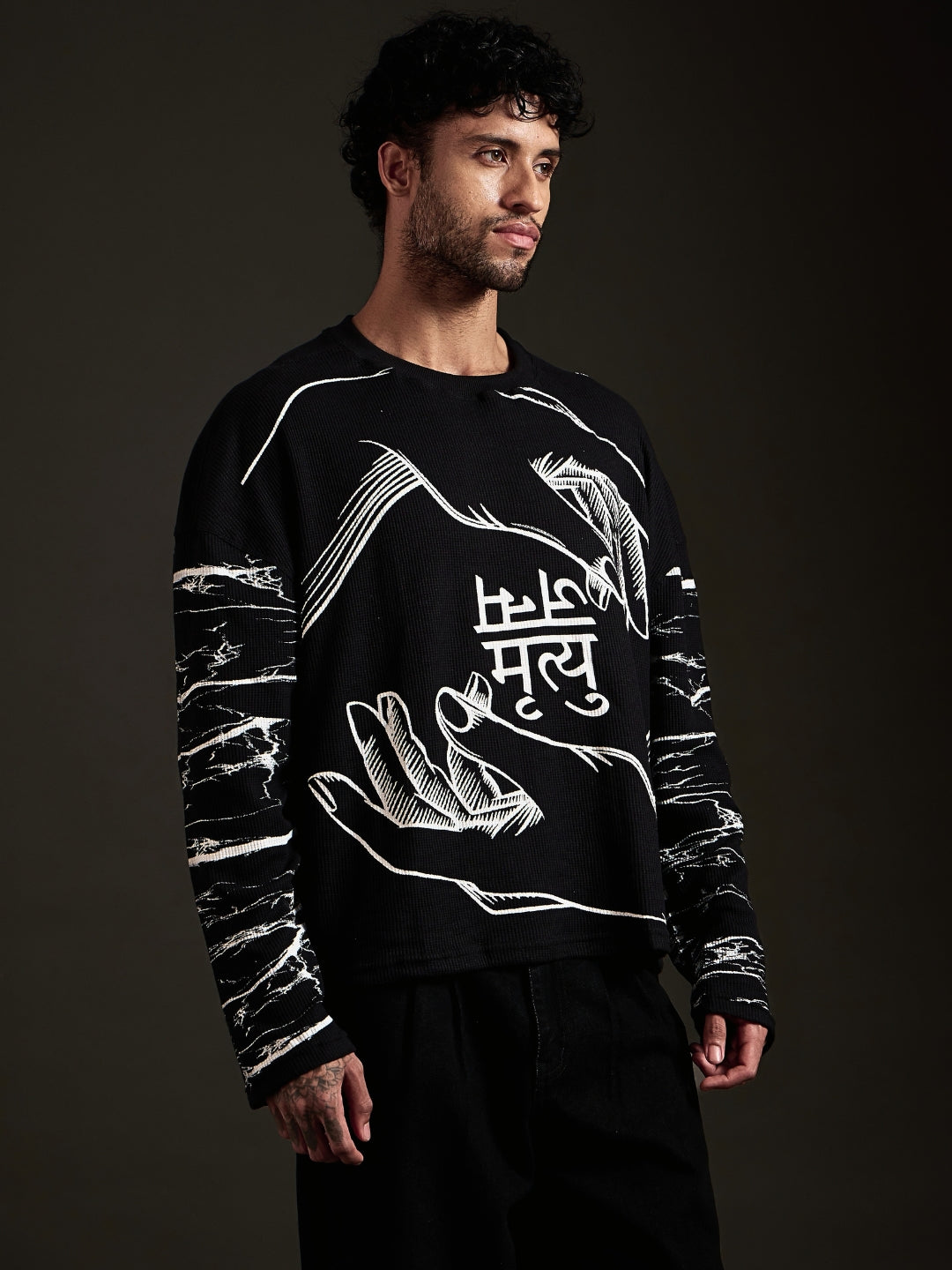 Side view of black oversized long sleeve tee with marble print sleeves
