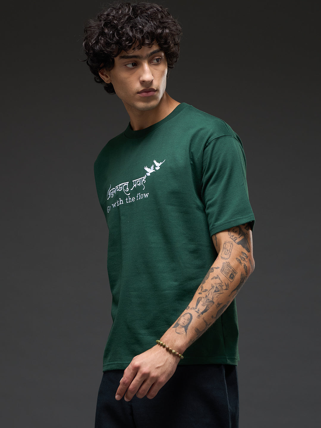 Bottle green recycled oversized tee by Rudrajap featuring "Go With The Flow" embroidery on front.