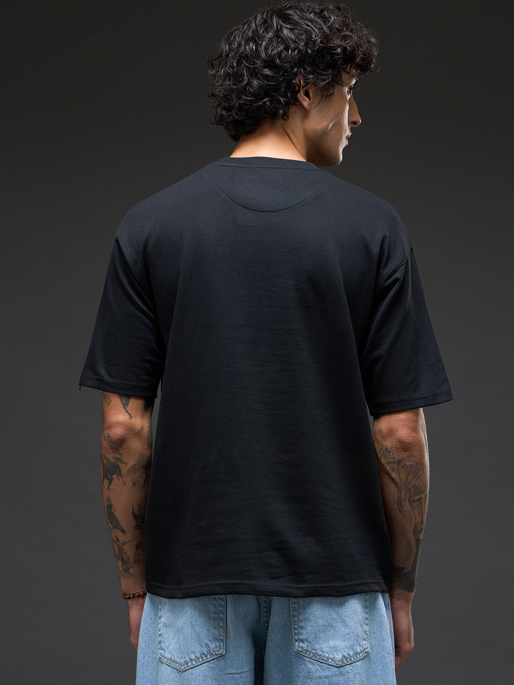 Black and mustard recycled oversized T-shirt by Rudrajap with bold color blocking and relaxed fit, displayed on a hanger.