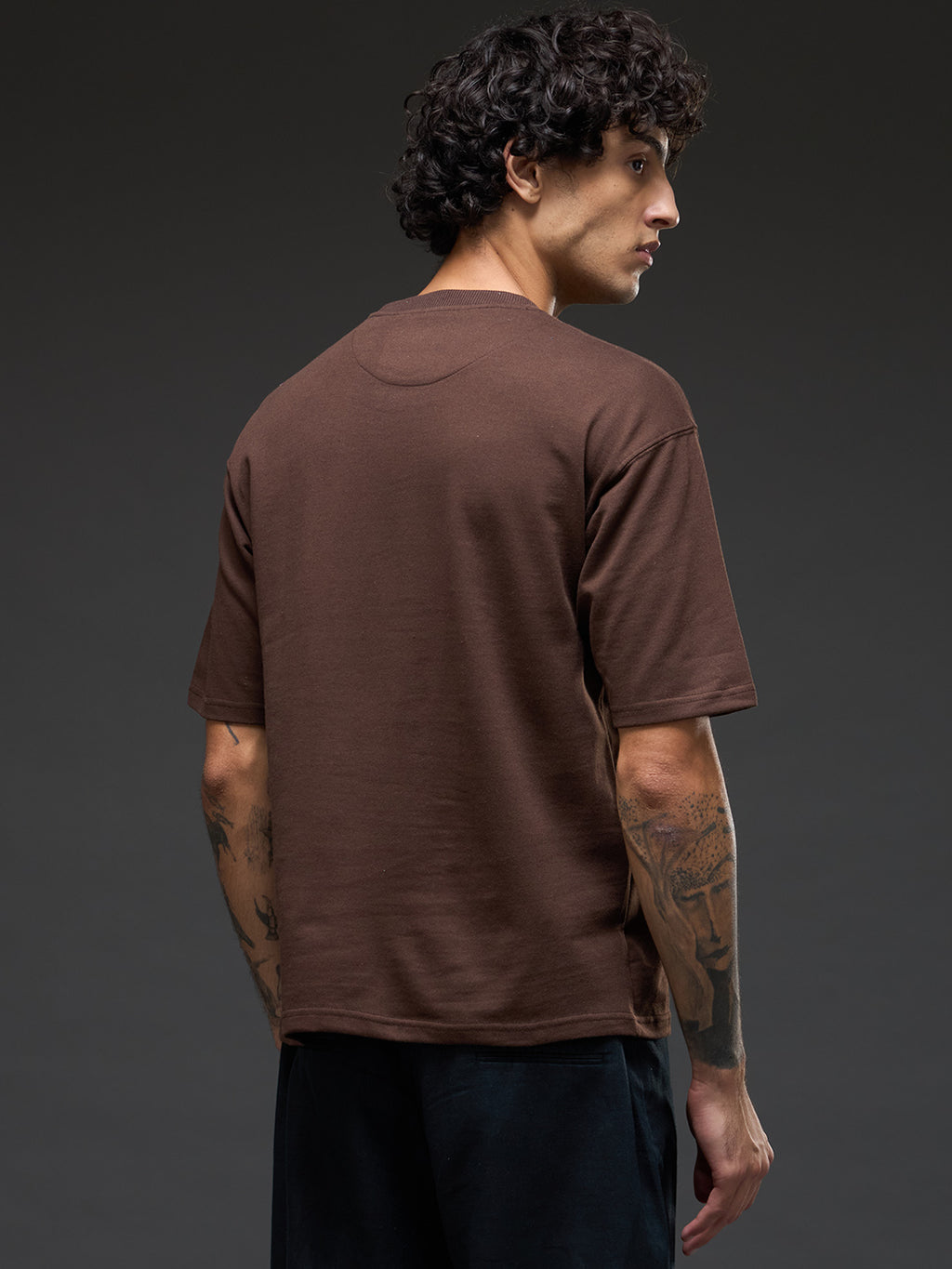 Brown recycled oversized tee from Rudrajap featuring embroidered "Never Give Up" slogan on soft, sustainable fabric.