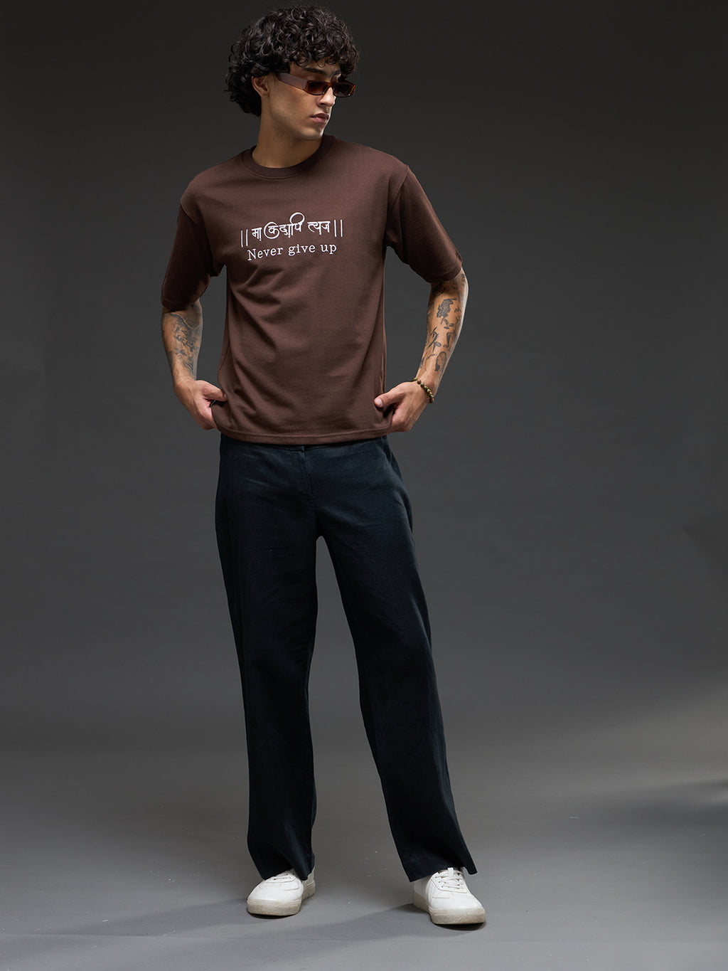 Brown recycled oversized tee from Rudrajap with "Never Give Up" embroidery, featuring a relaxed fit and eco-friendly fabric.