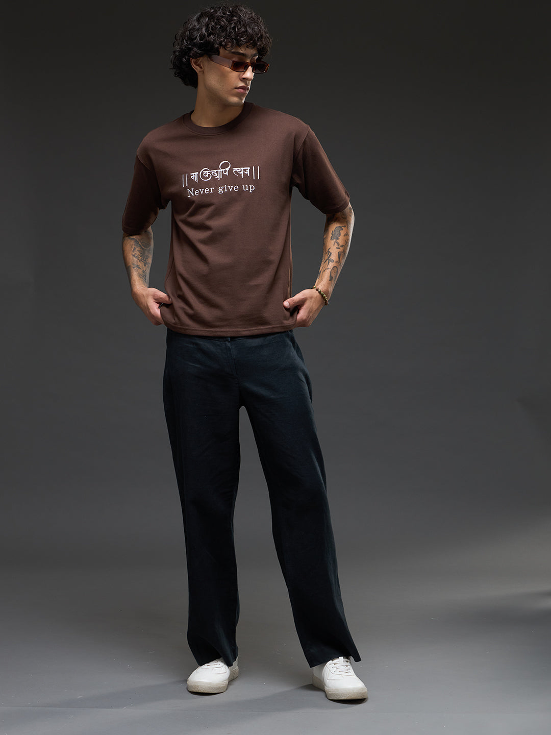 Brown recycled oversized tee from Rudrajap with "Never Give Up" embroidery, featuring a relaxed fit and eco-friendly fabric.