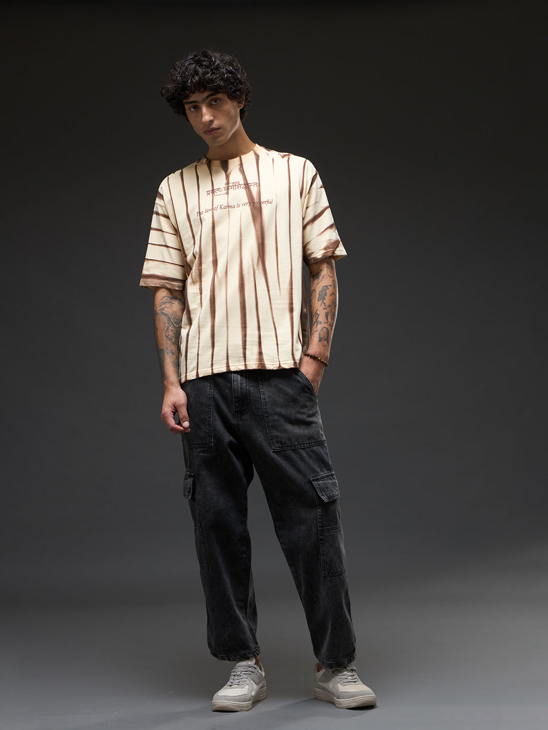 Beige oversized T-shirt with spray and puff print from Rudrajap's Law of Karma collection, shown flat with sleeve details.