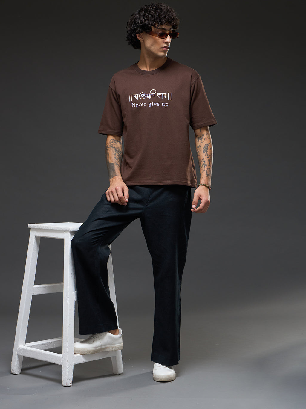 Brown recycled oversized tee by Rudrajap with embroidered "Never Give Up" slogan, casual fit, and eco-friendly fabric.
