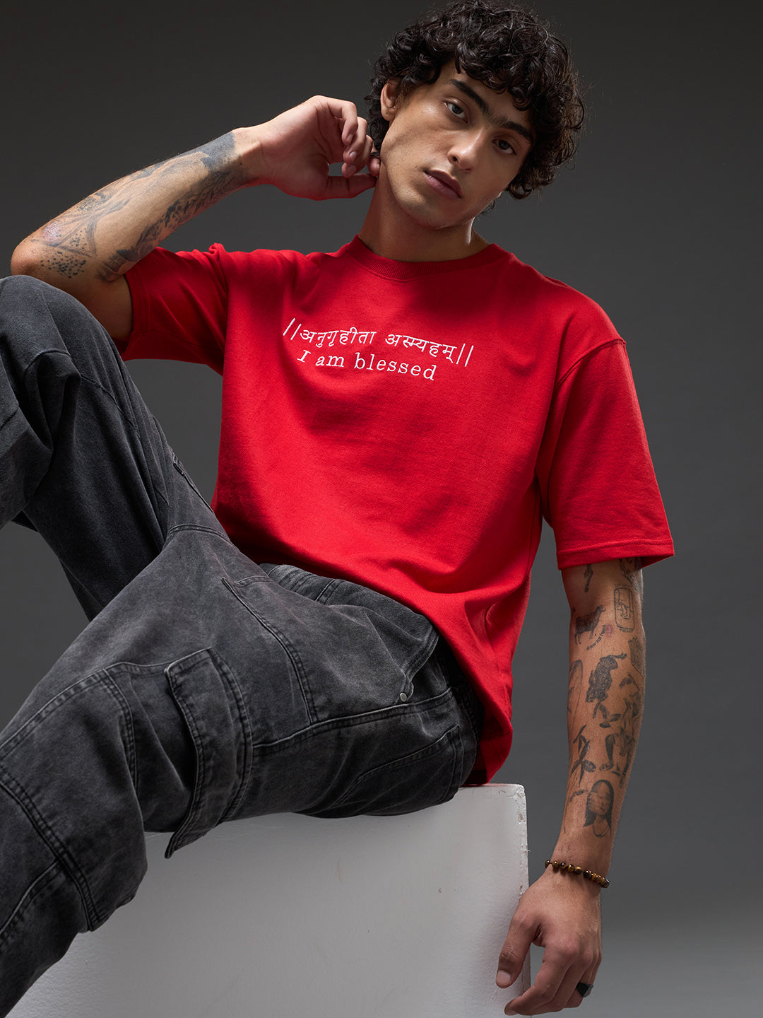 Red recycled oversized tee by Rudrajap with premium embroidered "I Am Blessed" text, relaxed fit and casual style.