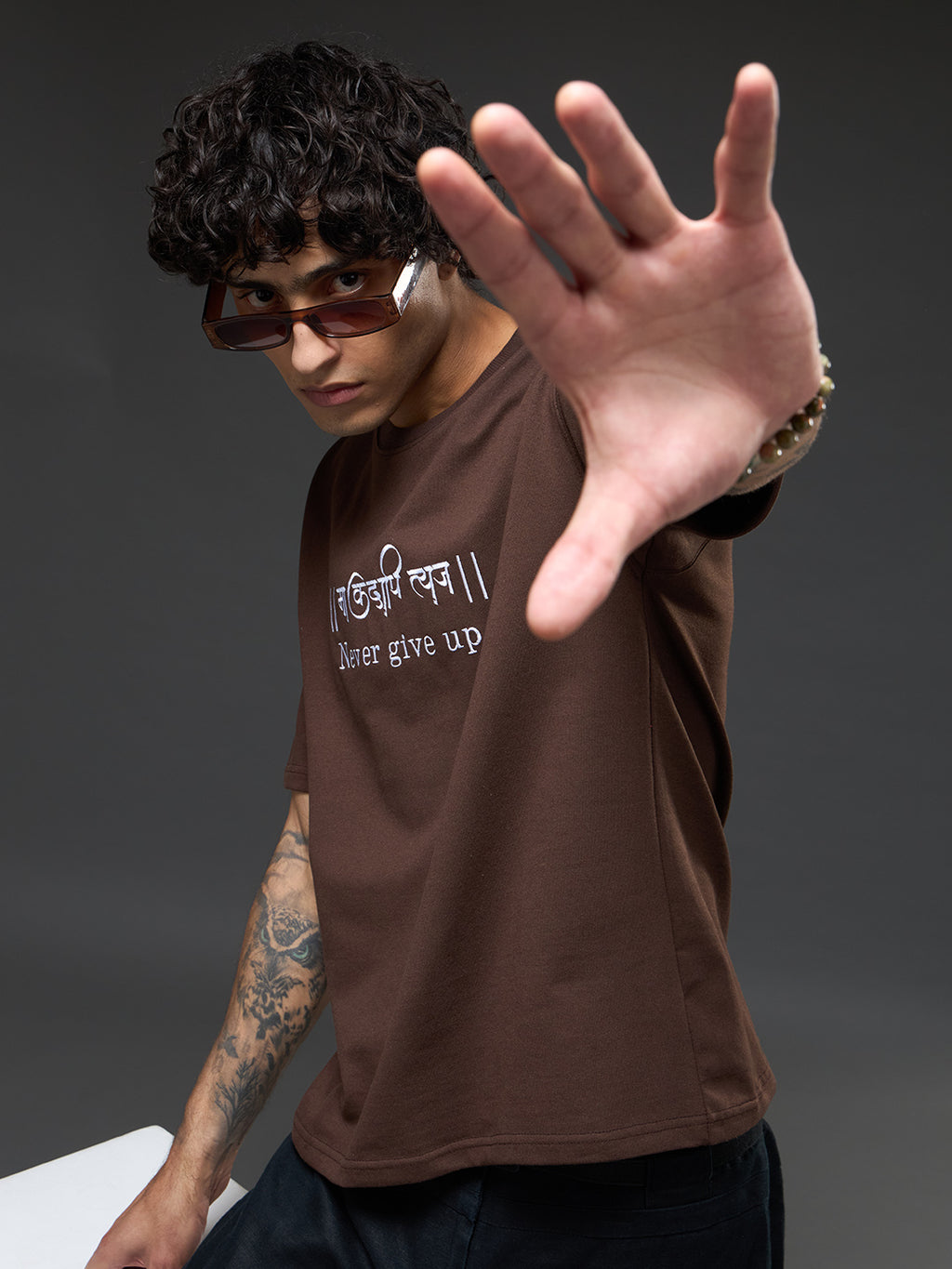 Brown recycled oversized tee by Rudrajap with embroidered "Never Give Up" message, casual fit and eco-friendly fabric.