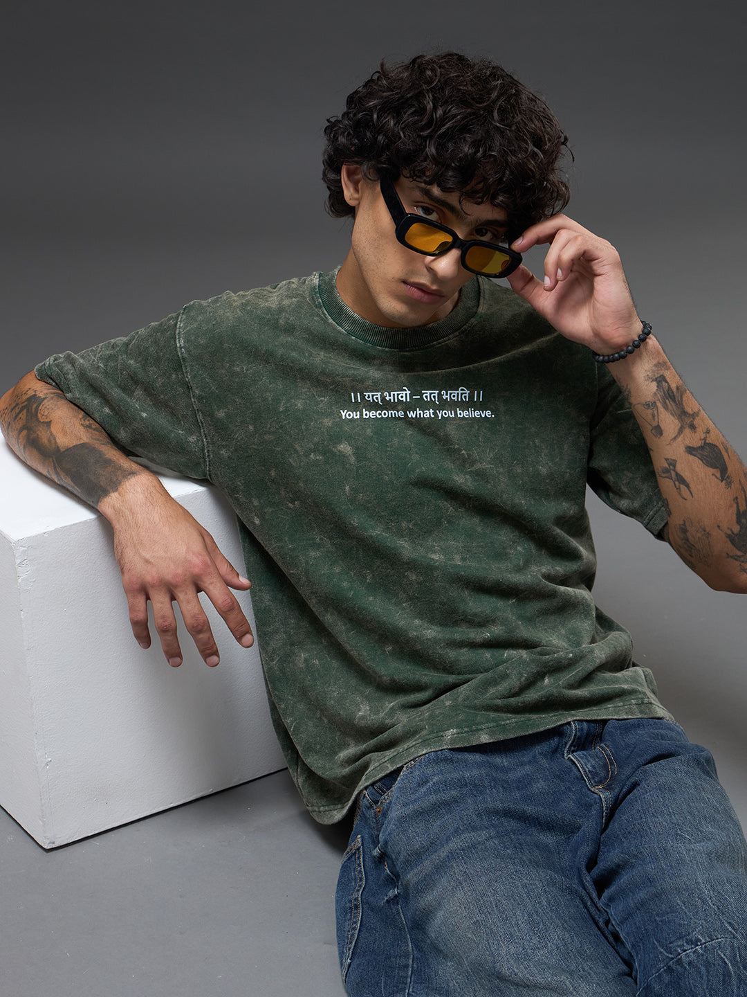 Moss green oversized burnout T-shirt by Rudrajap with relaxed fit and distressed fabric, displayed on a hanger.