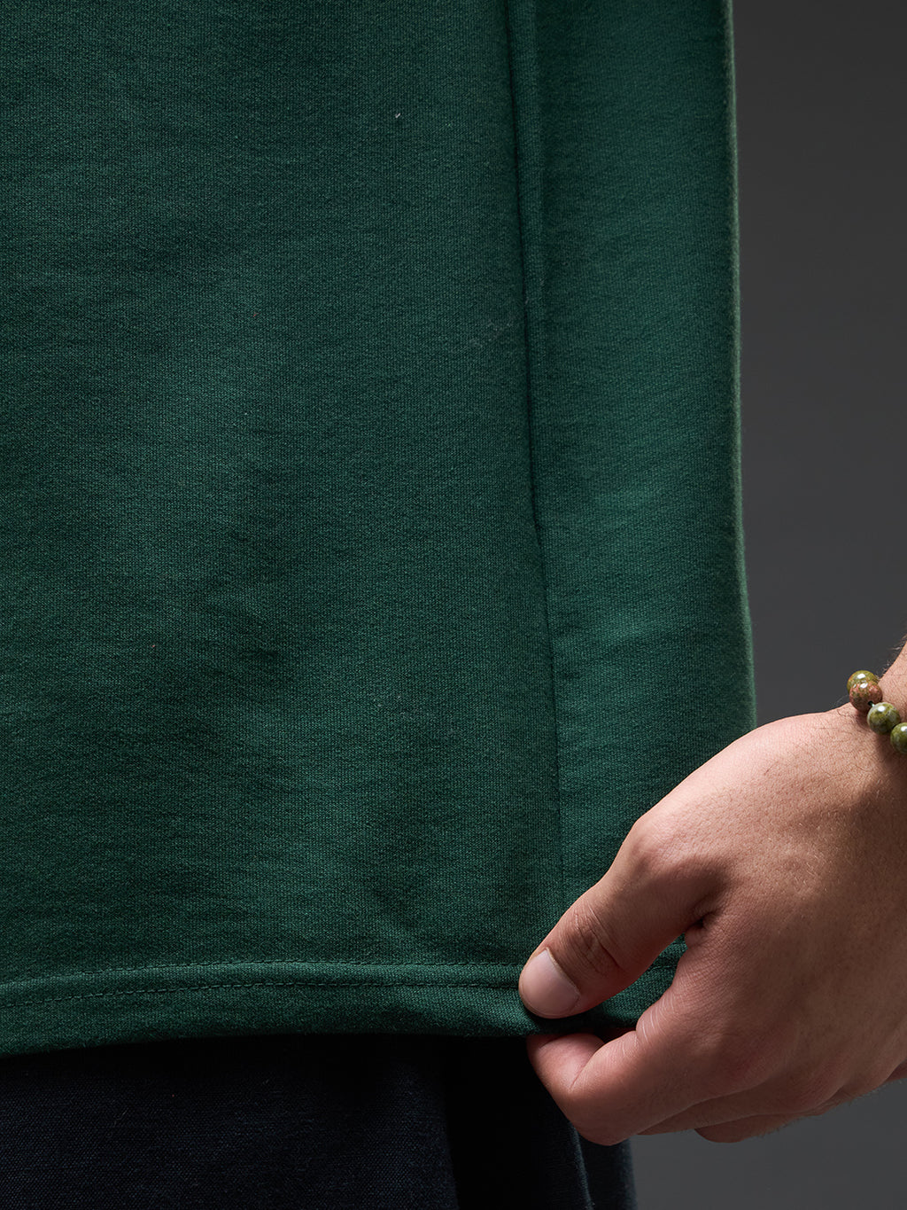 Bottle green recycled oversized tee by Rudrajap with "Go With The Flow" embroidery, shown flat with visible embroidery details.